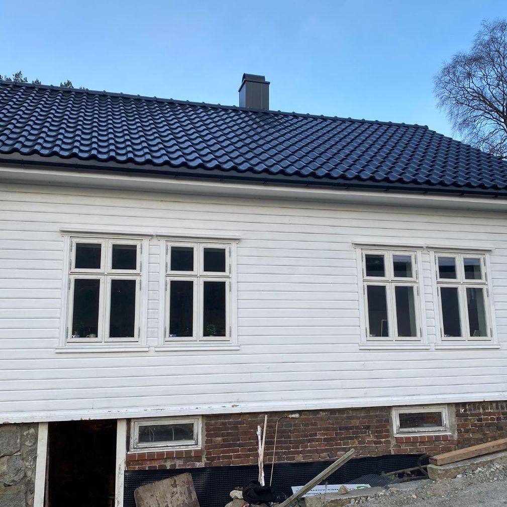 Hus i hvitt tre med svart tak