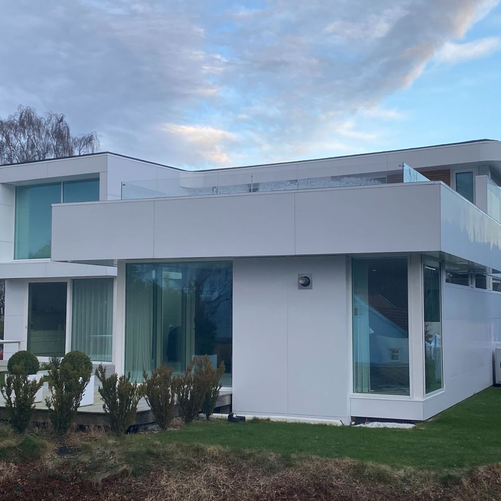 Hvitt moderne hus med store vindu